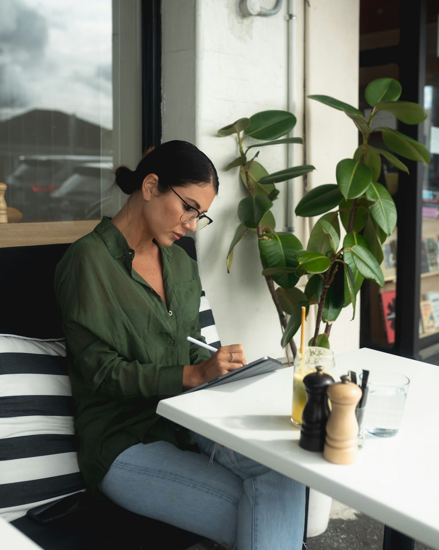 A woman writing at a desk by the window
